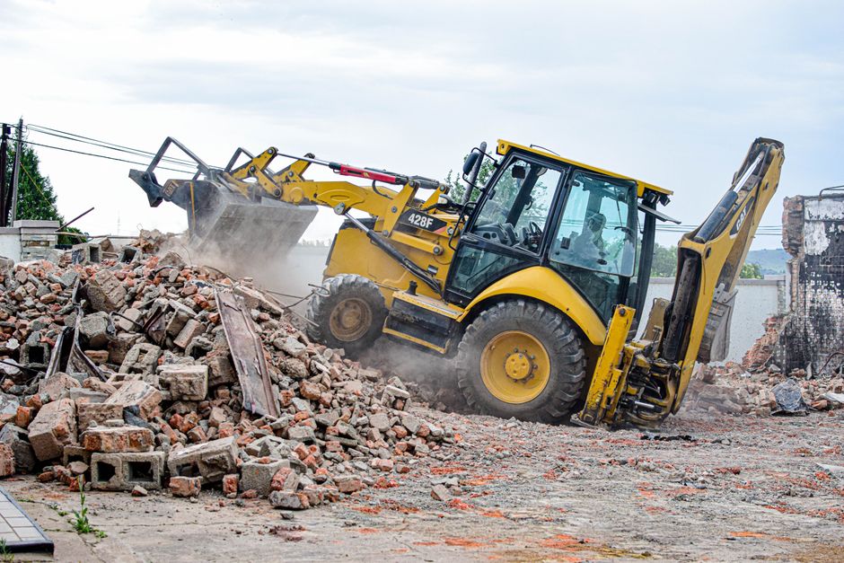 Excavator removing rubble at a demolition site.